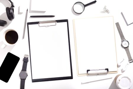 Black and white clipboards with clear sheets of paper on office table with cellphone and cup of coffee, copy spaceの写真素材