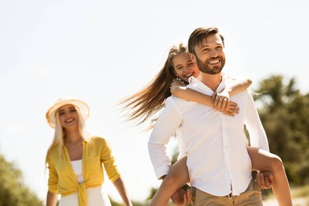 Happy family. Father playing with daughter outdoors, walking together in natureの写真素材
