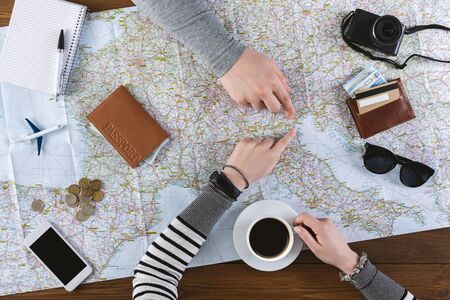 Trip planning concept. Unrecognizable couple planning where to go on holiday this year