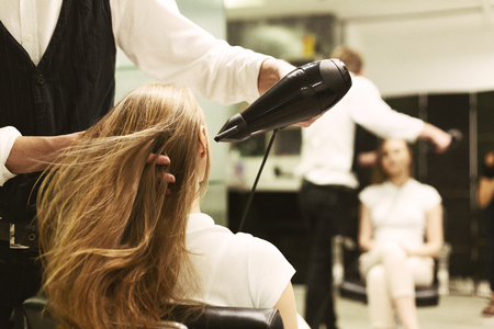 Hairdresser Drying Womans Hair With Hair Dryer In Beauty Studio. Selective Focus, Empty Spaceの写真素材