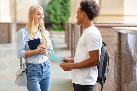 Chatting with classmate. Students talking in college campus, having break between classes