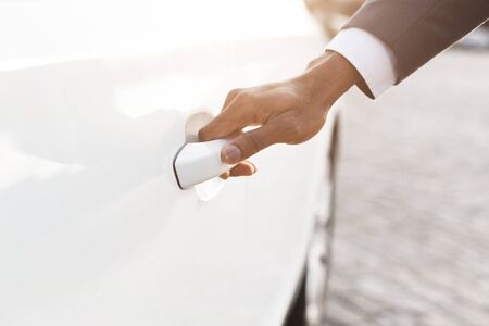 Hand on handle. Male hand in formalwear opening car door, closeup