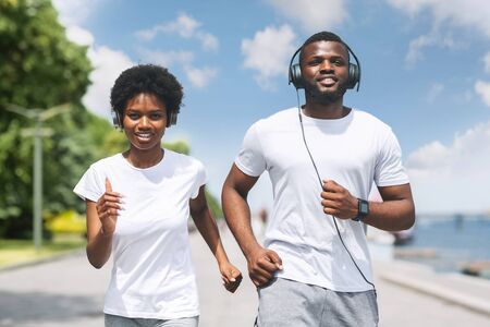Morning Jog. Young African American Couple Running Or Trotting Along River Bank.の写真素材