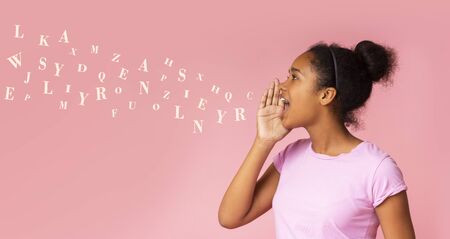 Gossip girl. African american teen screaming at copy space, diverse alphabet letters flying out of her mouth. Panoramaの写真素材