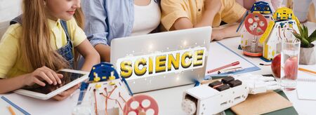 Group of kids studying on laptop with inscription Science, panoramaの写真素材