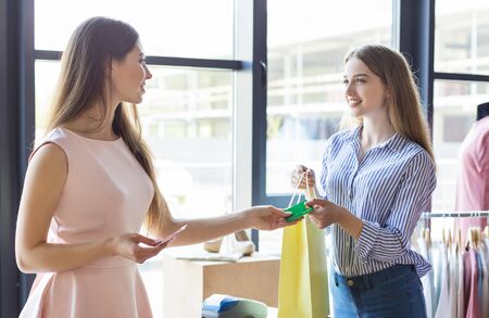 Caucasian Young Lady Paying With Credit Card For Purchase At Boutiqueの写真素材