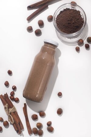 Brown healthy smoothie with cinnamon on white background with spices, vertical panoramaの写真素材