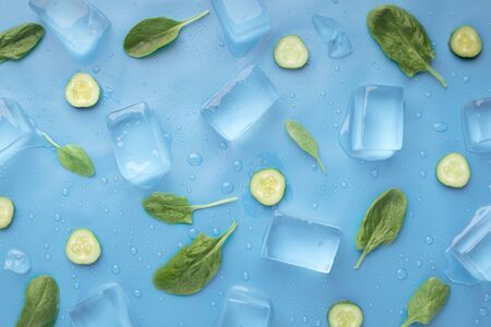 Fresh summer wallpaper with cucumbers and ice cubes on blue backgroundの写真素材