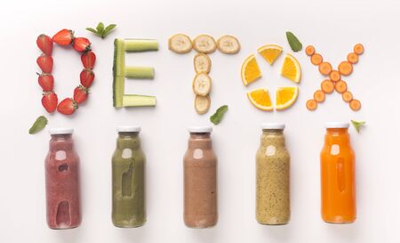 Detox concept. Colored healthy cocktails of fruits and vegetables in glass bottles with text above on white background, panoramaの写真素材