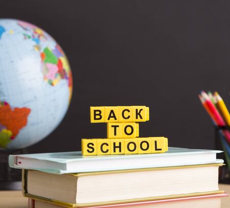 Back to school concept. Close up of White plastic text and school stationery over chalkboard background with copy spaceの写真素材