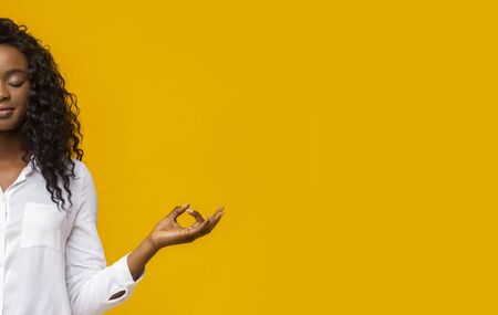 Harmony concept. Half portrait of meditating black woman with closed eyes, free spaceの写真素材
