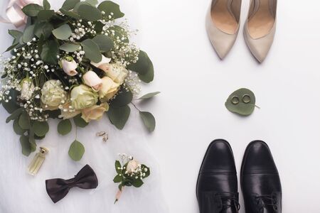 Bridal room. Wedding bouquet, her and his shoes on white backgroundの写真素材