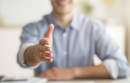 Handshake Gesture. Smiling Man Stretching Hand For Greeting Sitting At Home. Shallow Depth, Croppedの写真素材
