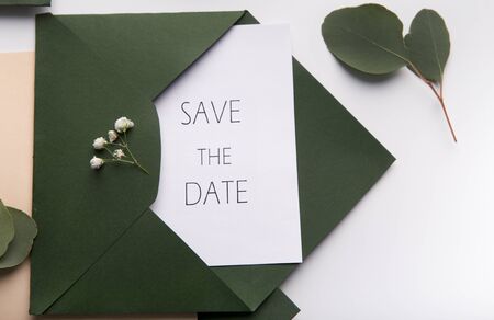 Save the date concept. Close up of Wedding Green envelope with postcard inside on white background