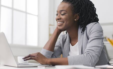 Smiling Afro Businesswoman Typing Something Working On Laptop In Office. Copy Space
