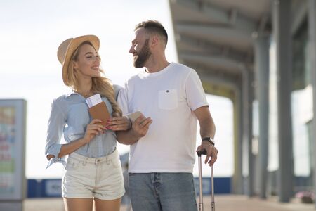 Newlyweds arriving at airport, going on honeymoon and holding tickets outdoors, free spaceの写真素材