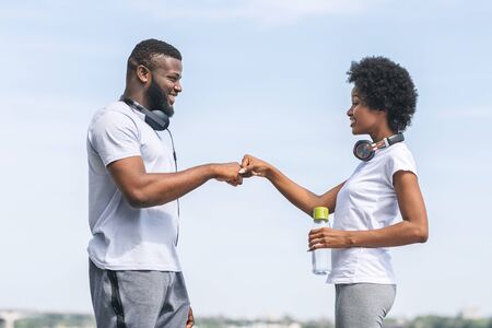 African American Couple Giving Fist Bump After Morning Jogging Outdoor. Running And Healthy Lifestyle.の写真素材