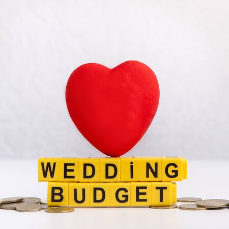 Close up of red heart with wedding budget text on coins for spendingsの写真素材