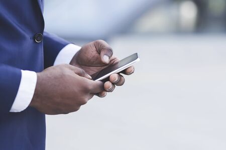 Business Apps. Closeup Of Black Businessman Hands Using Smartphone Outdoor In City. Empty Space For...