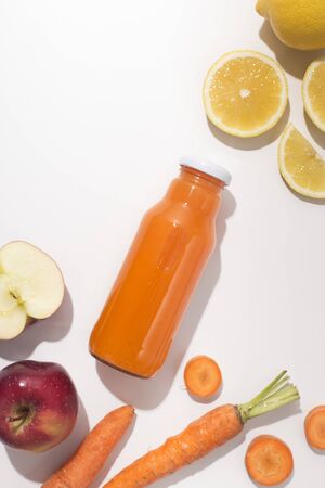 Natural organic and healthy juice in glass bottle with ingredients on white background, vertical panoramaの写真素材