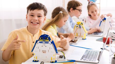 Happy schoolboy showing his robot, being proud of his project, panoramaの写真素材