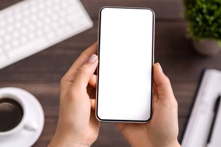 Woman demonstrating new modern smartphone with blank white screen for advertisement or application...