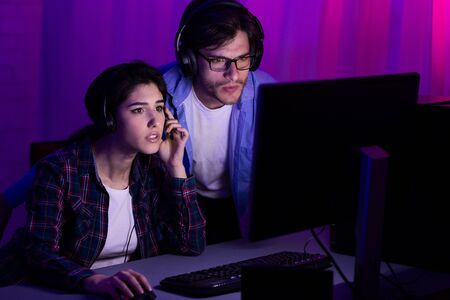Gamers playing PC video game on eSport tournament, looking at computer monitorの写真素材