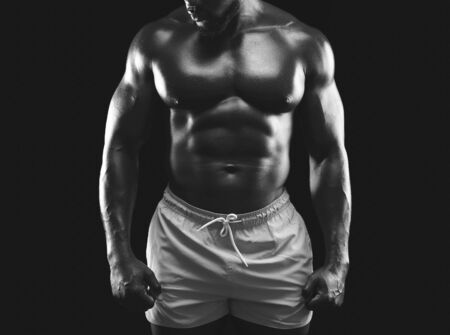 Bodybuilding and fitness concept. African american male bodybuilder demonstrating muscular body, studio background, monochrome photoの写真素材