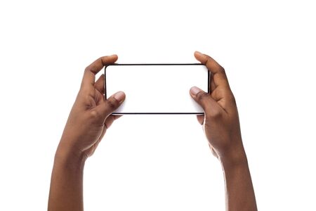 Black womans hands holding smartphone with blank screen and playing video games