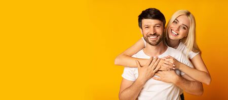 Romantic Relationship. Happy Man And Woman Embracing Over Yellow Studio Background. Panorama, Copy...