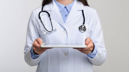 Medical Technologies. Unrecognizable Doctor Holding Digital Tablet Standing On White Background In Studio. Panorama, Croppedの写真素材
