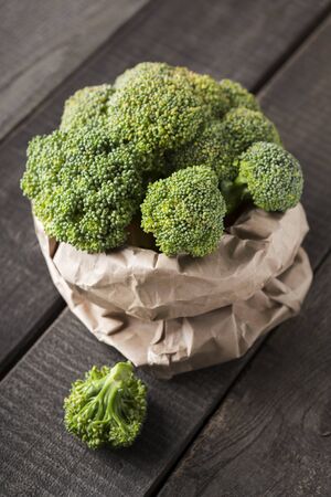 Healthy nutrition concept. Eco coton sack full of green fresh broccoli on wooden background, vertical panoramaの写真素材