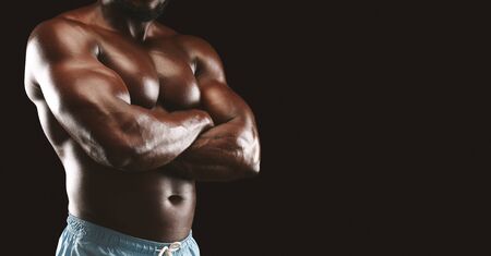 Confidence concept. African american bodybuilder crossed his arms on chest, panorama with free spaceの写真素材