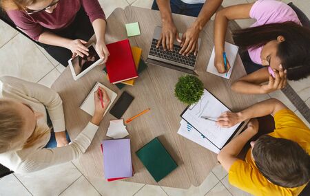 Education, high school, people and technology concept. Group of international students sitting at...