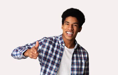 Hey you! Cheerful black guy indicating happily at camera, white studio backgroundの写真素材
