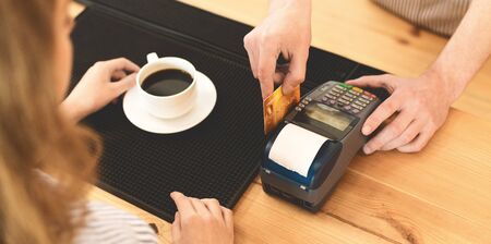 Fast transactions. Woman paying with gold credit card in cafe for tasty americano, panorama