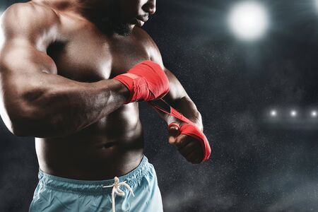Afro fighter wrapping his fists, staying on boxing ring, copy spaceの写真素材