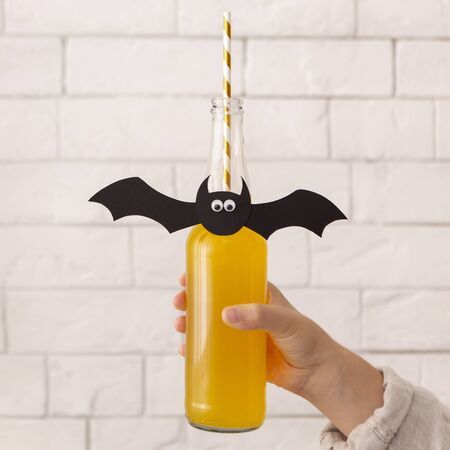 Drink for halloween. Yellow season pumpkin cocktail specially cooked for holiday in woman handの写真素材