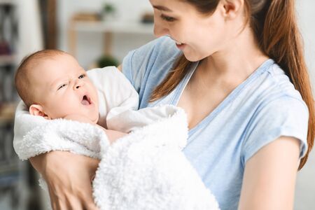 Time to sleep. Cute newborn baby sweetly yawning on mothers hands