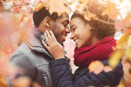 Happy tender couple at autumn day in the forest, embracing and enjoying moment togetherの写真素材