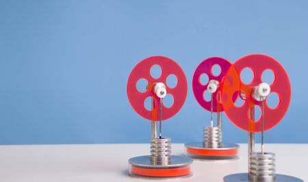 Robotics in manufacturing. Set of red plastic gears for energy producing, blue background with free...