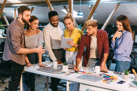 Colleagues working together with tablet and palette, choosing colors for new projectの写真素材