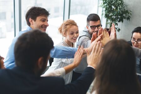 Motivated successful business team giving high five, team building unity conceptの写真素材