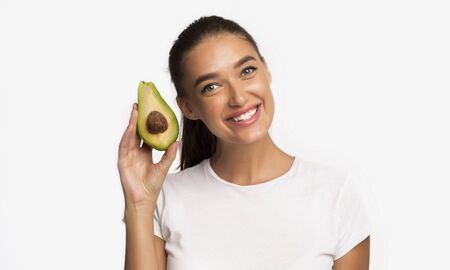 Healthy Fats. Smiling Woman Holding Avocado Standing Over White