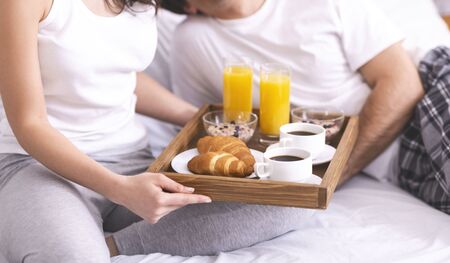 Breakfast in bed. Loving caucasian couple enjoying healthy brunch, panoramaの写真素材