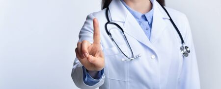 Unrecognizable Doctor Pressing Invisible Button On Medical Touchscreen Standing Over Gray Studio Background. Panorama, Croppedの写真素材