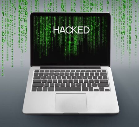 Malware concept. Laptop with hacked message on screen with binary code numbers on gray background