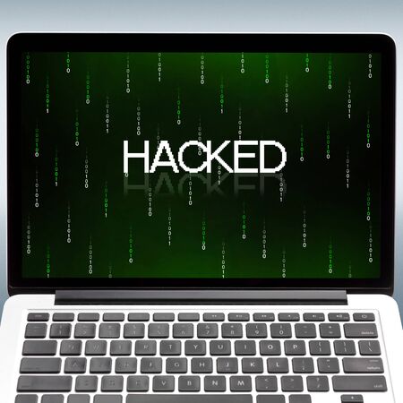 Computer hacking concept. Laptop with inscription hacked and binary code digits on screen, closeup