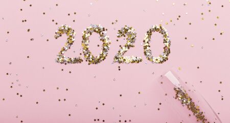 New Year celebration concept. Gold letters 2020 flying out of champagne glass on pink background, panoramaの写真素材
