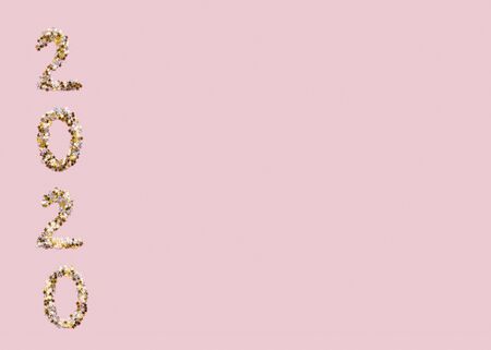 New Year concept. 2020 text of gold confetti on pink background, copy space for textの写真素材